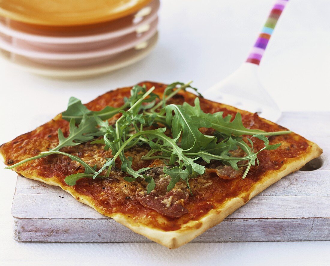 Pizza topped with bresaola and rocket