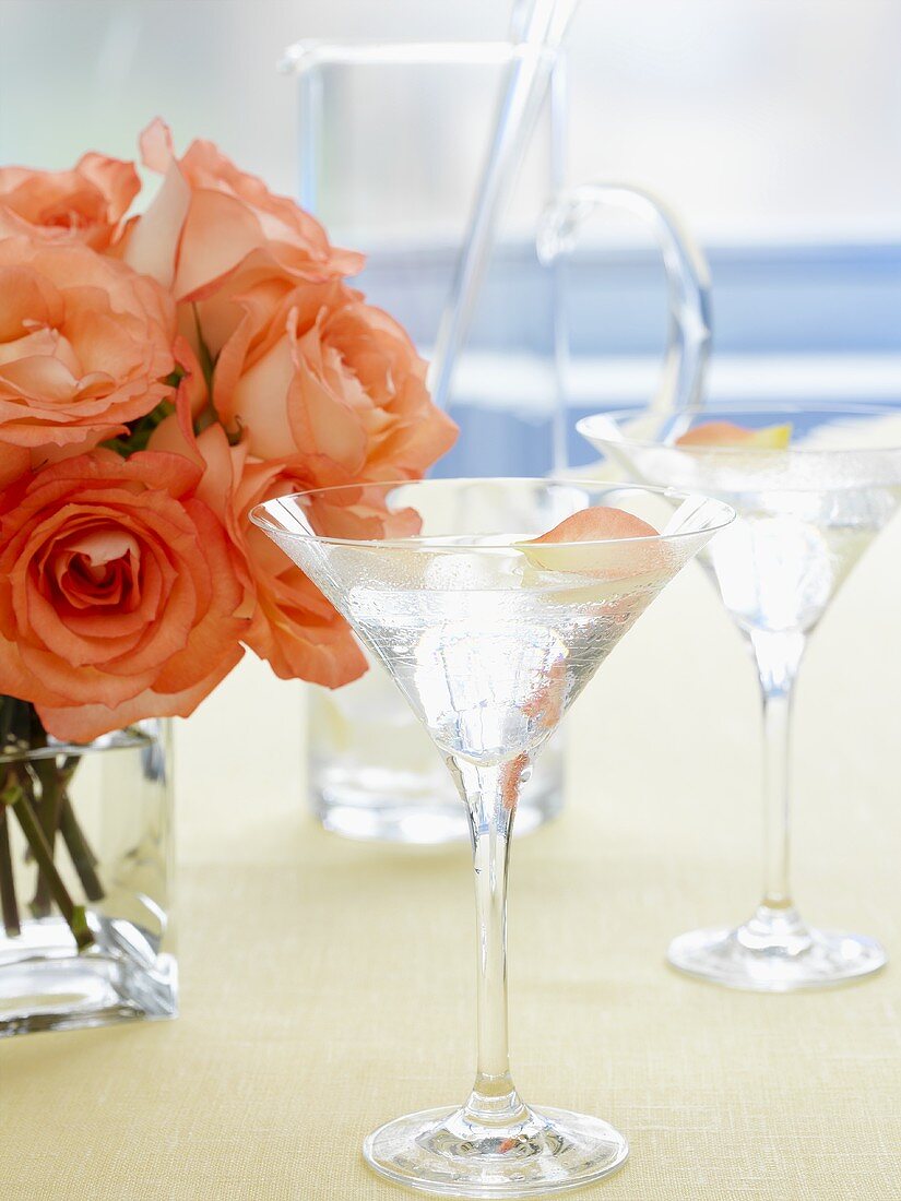 Zwei Gläser Martini mit Rosenblüten und Rosenstrauss
