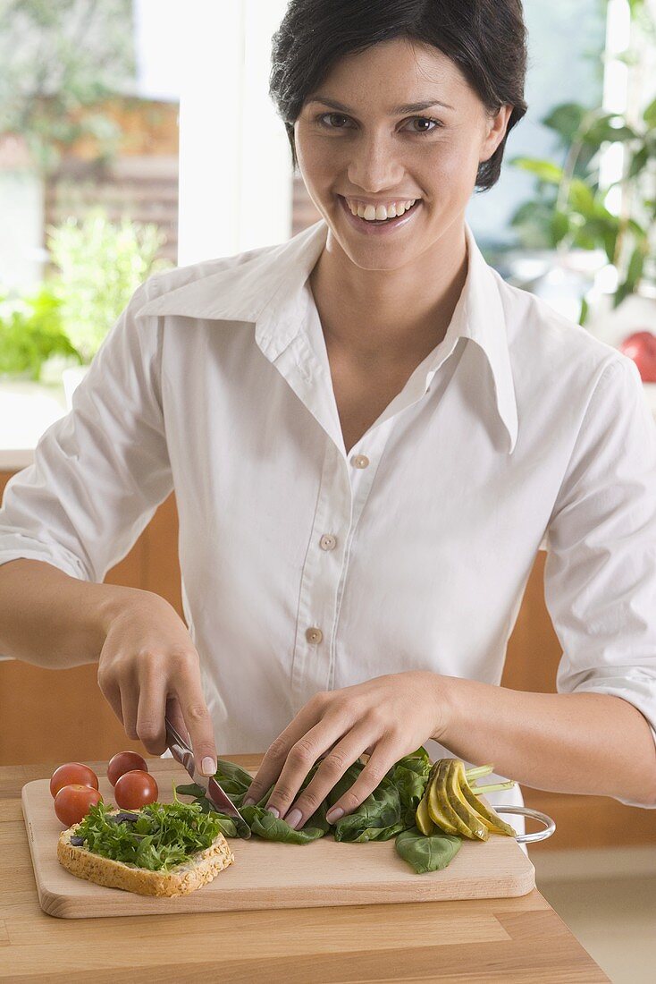 Young woman chopping herbs for a sandwich