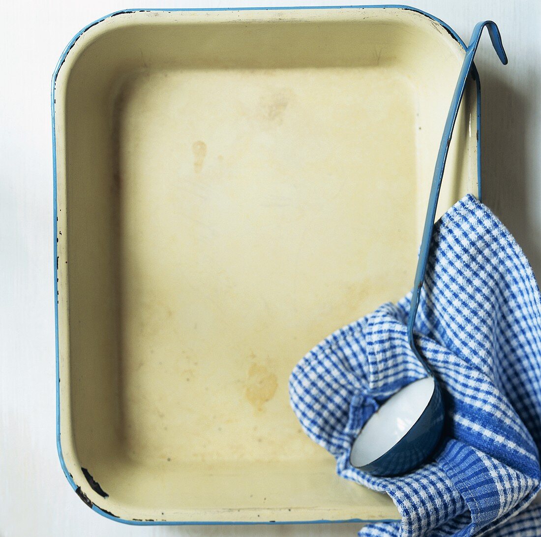 Baking dish with ladle and tea towel