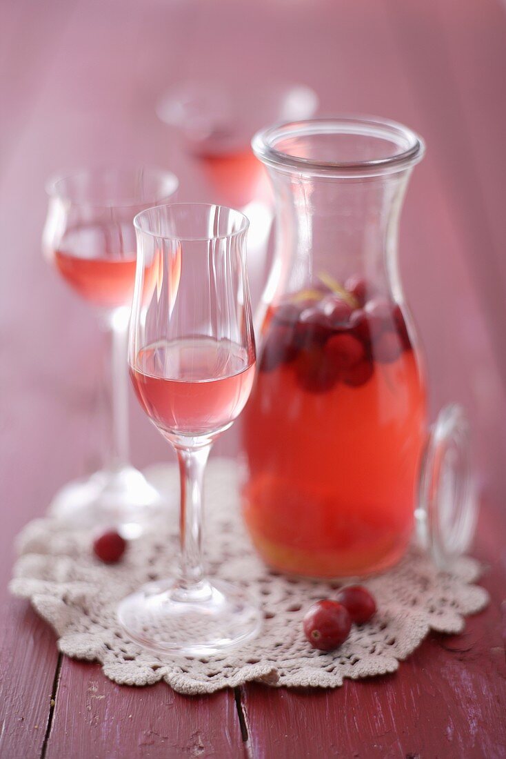 Cranberry-Likör in einer Karaffe und in Gläsern