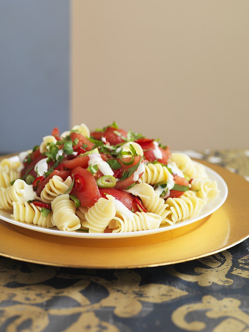 Spiral pasta salad with sweet and sour tomatoes and basil