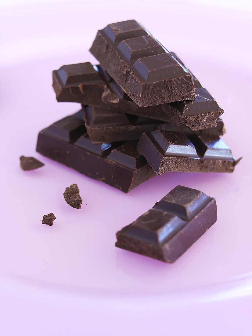 Pieces of chocolate on pink plate