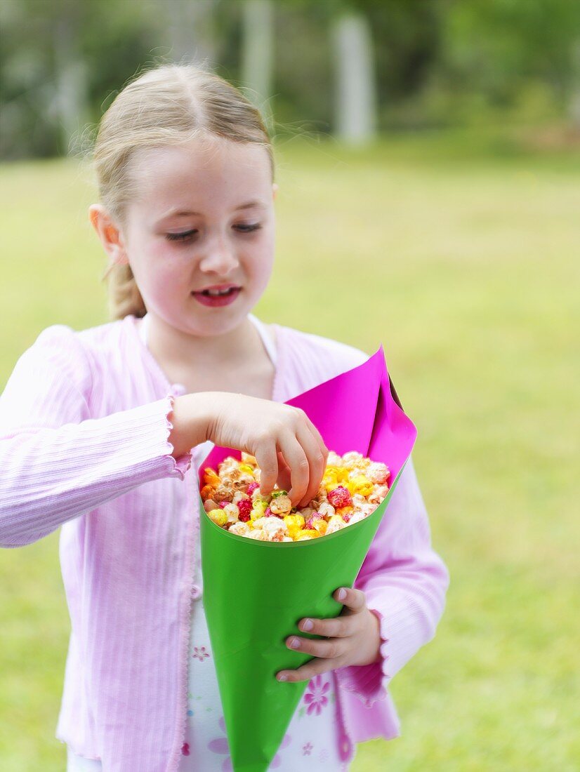 Blondes Mädchen mit einer Tüte Popcorn im Freien