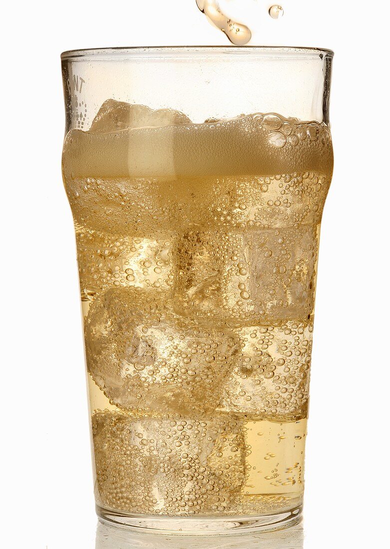 A glass of cider with ice cubes