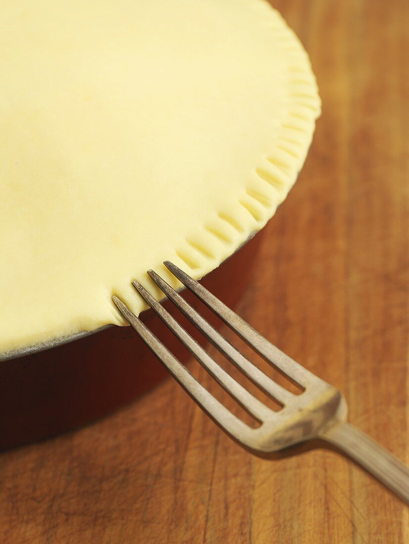 Pressing the edge of a pie with a fork