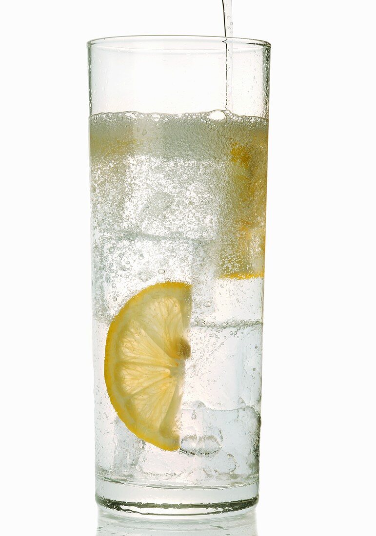 A glass of gin and tonic with slices of lemon