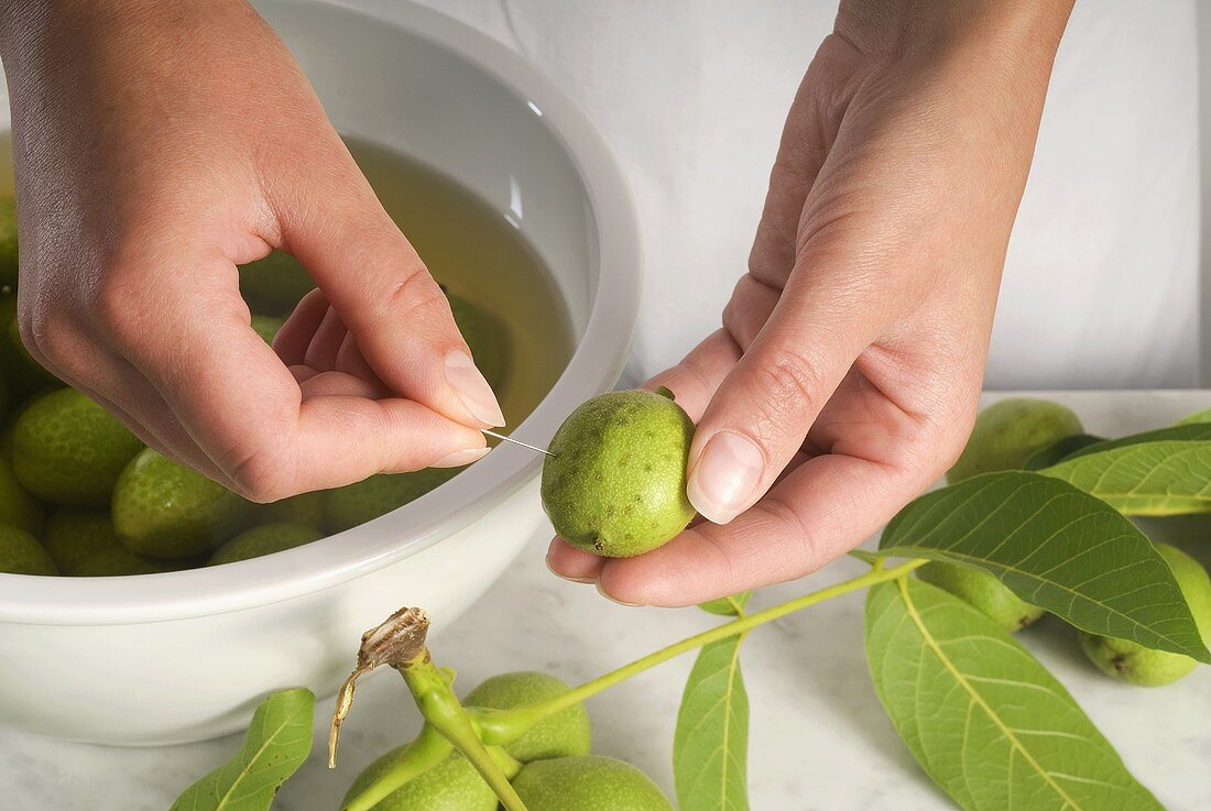 Pricking green walnuts with a needle (for pickled walnuts)