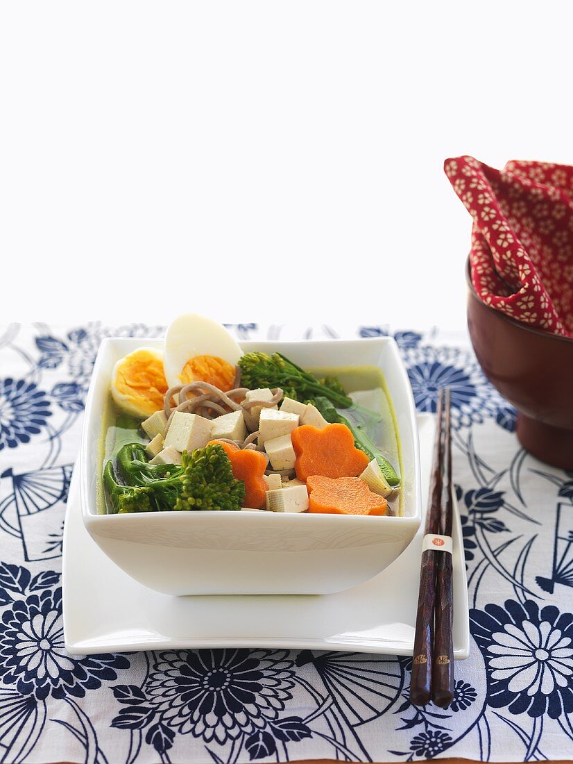 Asian vegetable soup with tofu, egg and ramen noodles