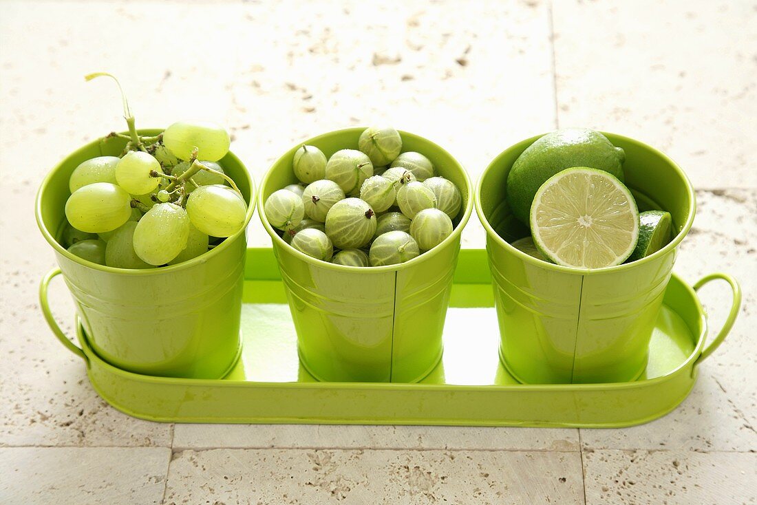 Grüne Trauben, Stachelbeeren und Limetten in grünen Bechern