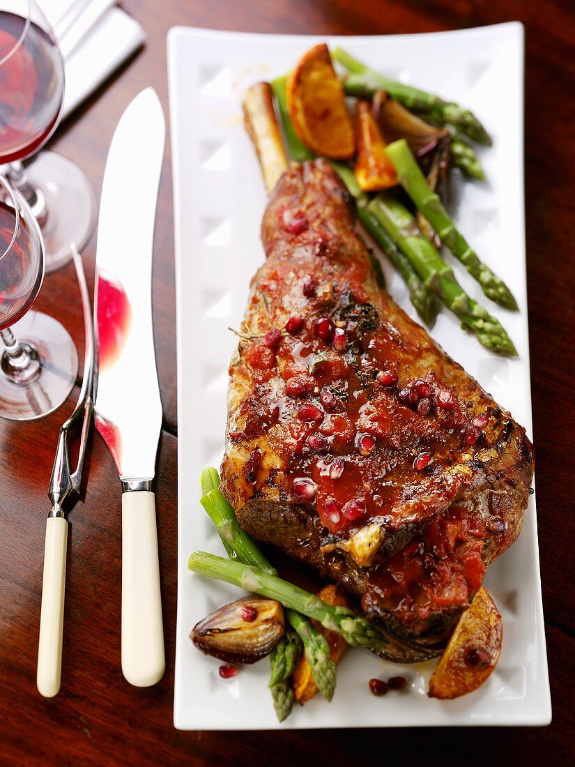 Leg of lamb with pomegranate seeds and green asparagus