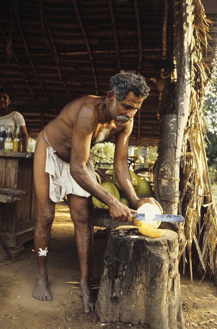 Mann schält eine King-Kokosnuss