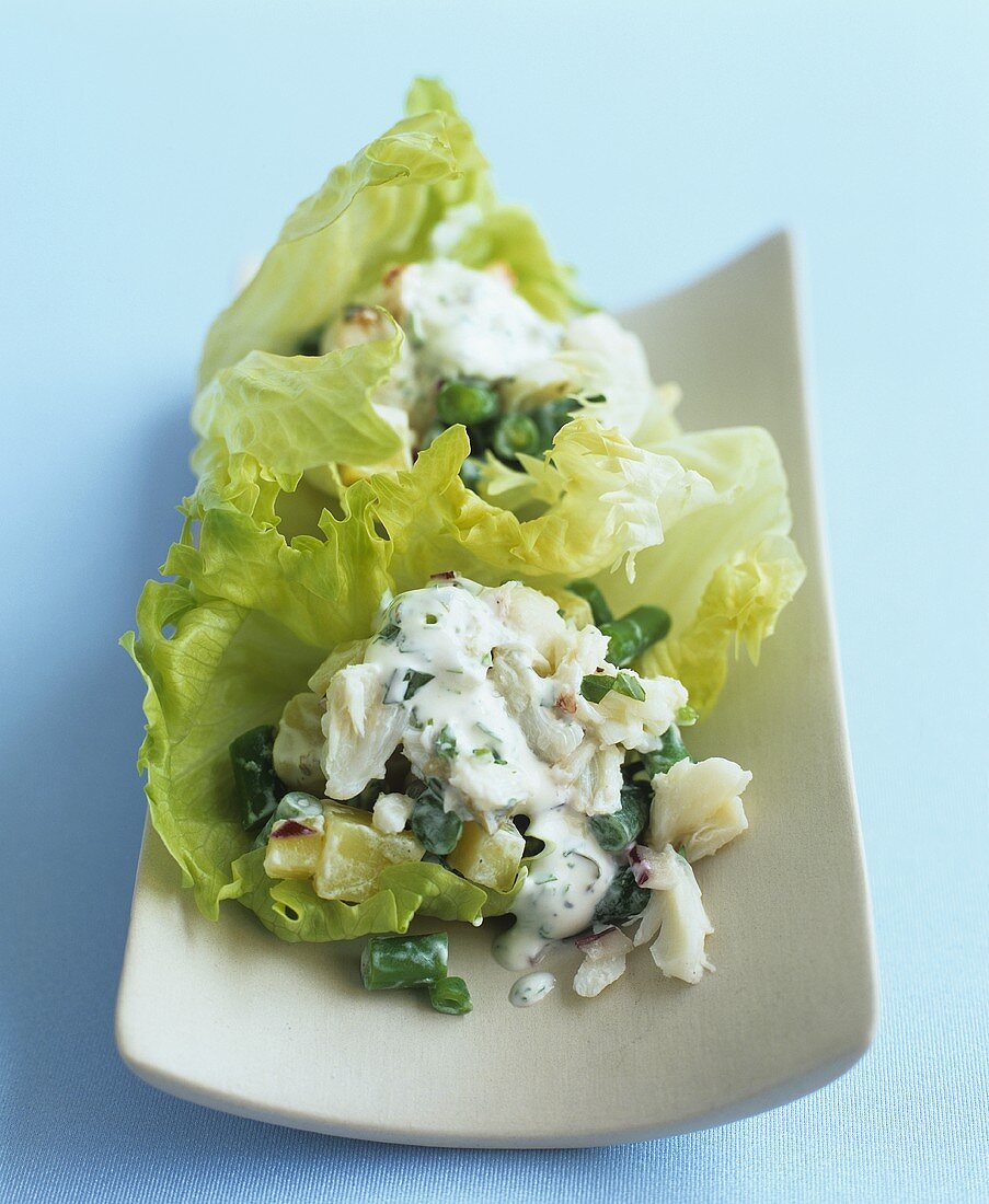 Potato salad with crabmeat on lettuce leaves