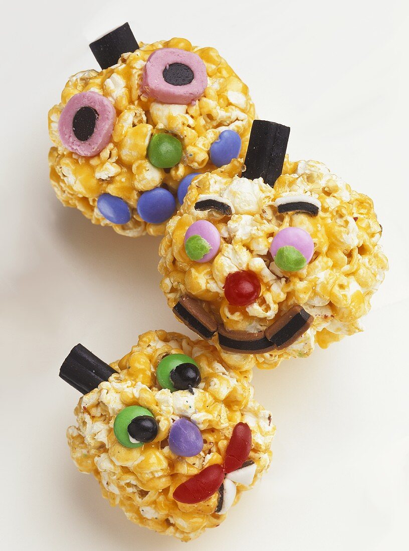 Amusing faces made with caramel popcorn and sweets