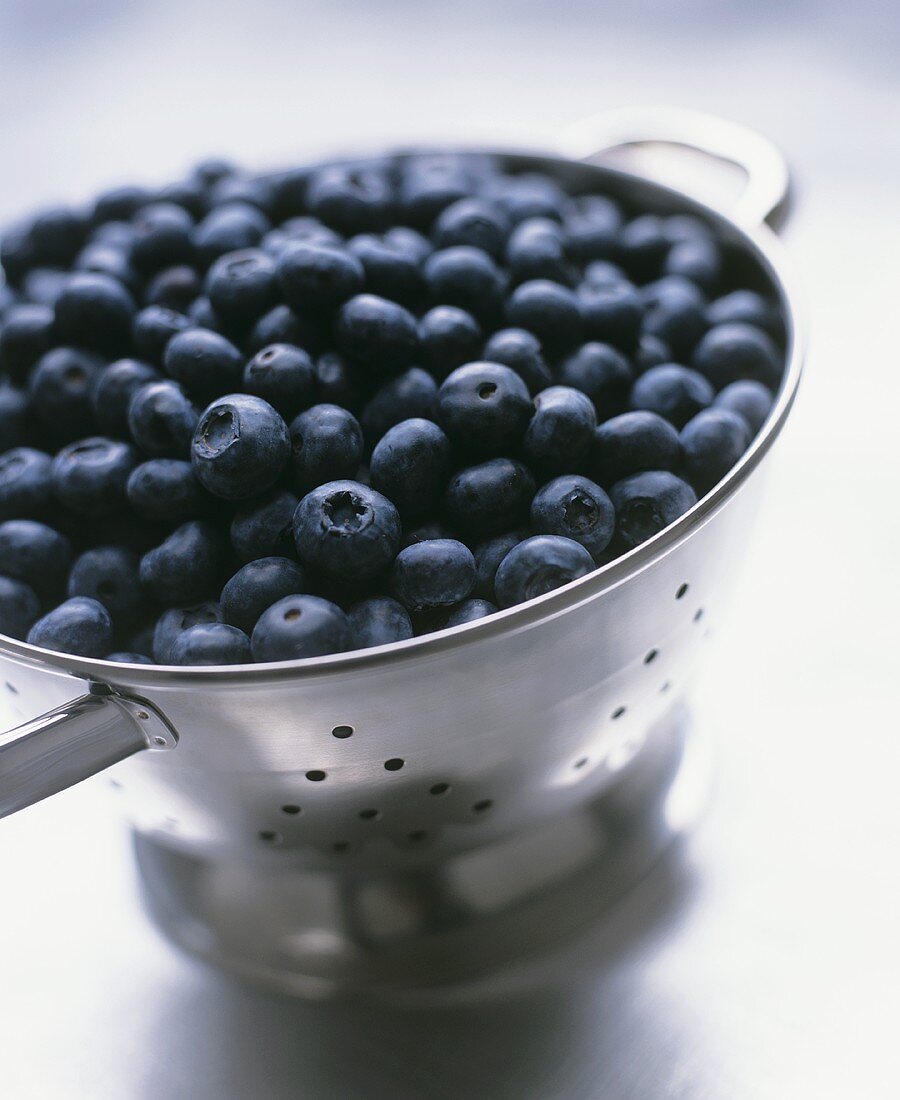 Fresh blueberries in a metal colander