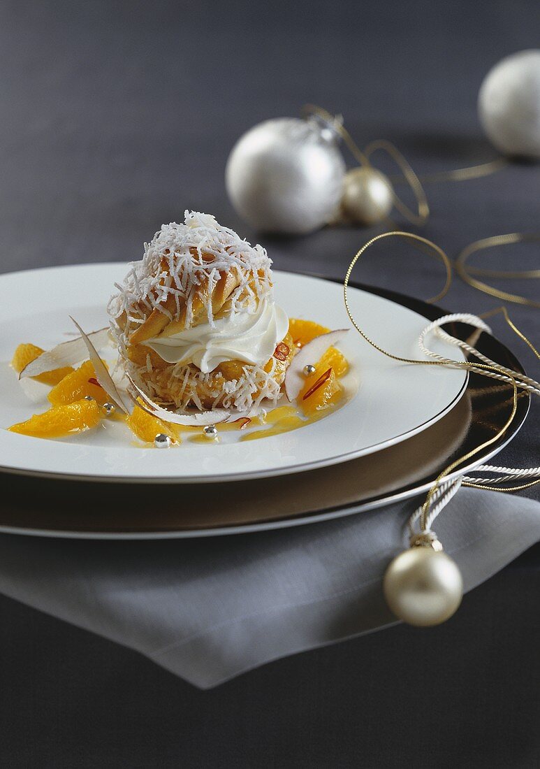 Cream-filed profiterole topped with desicated coconut and served with orange sauce