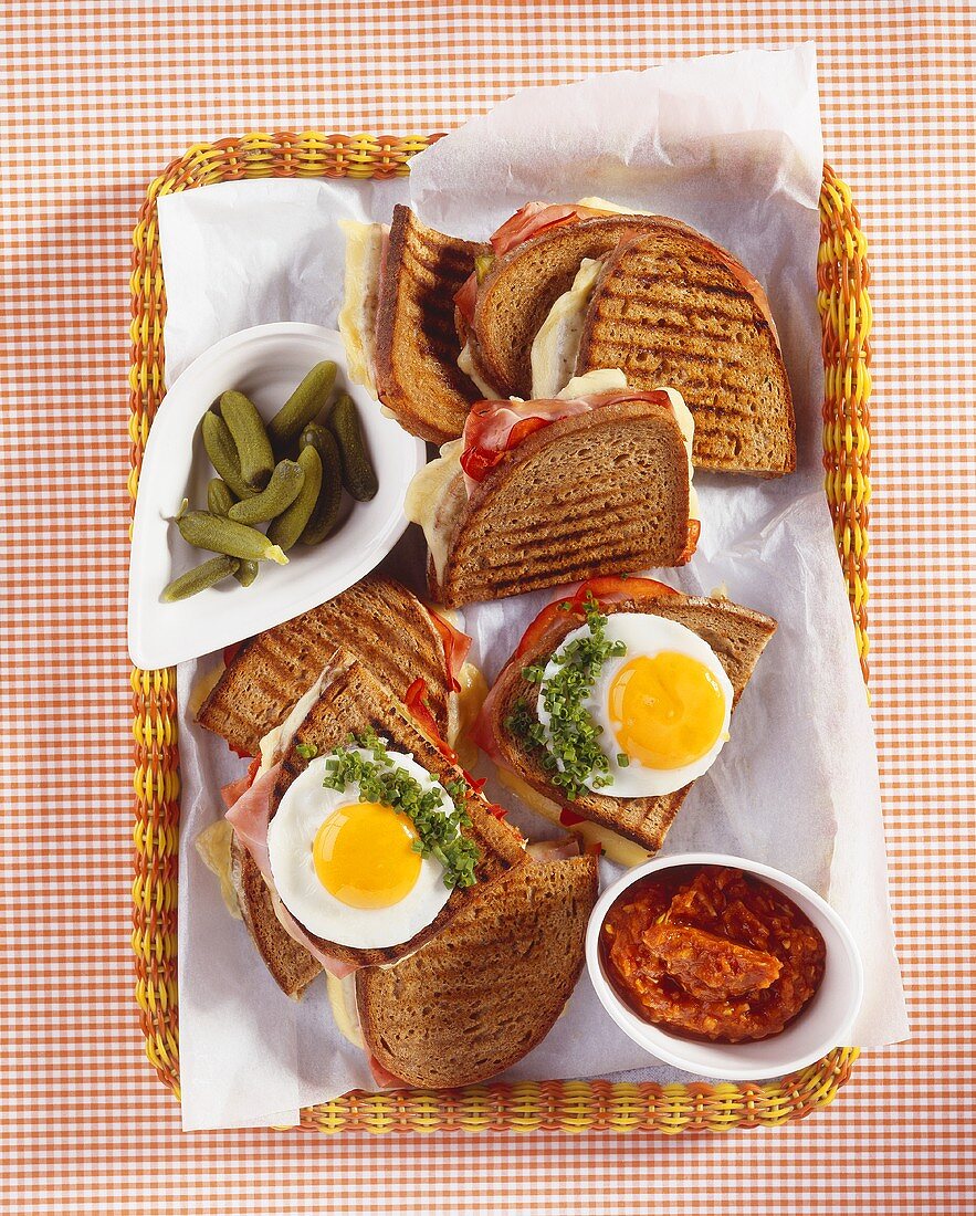 Toasted brown bread with fried eggs, ham and cheese