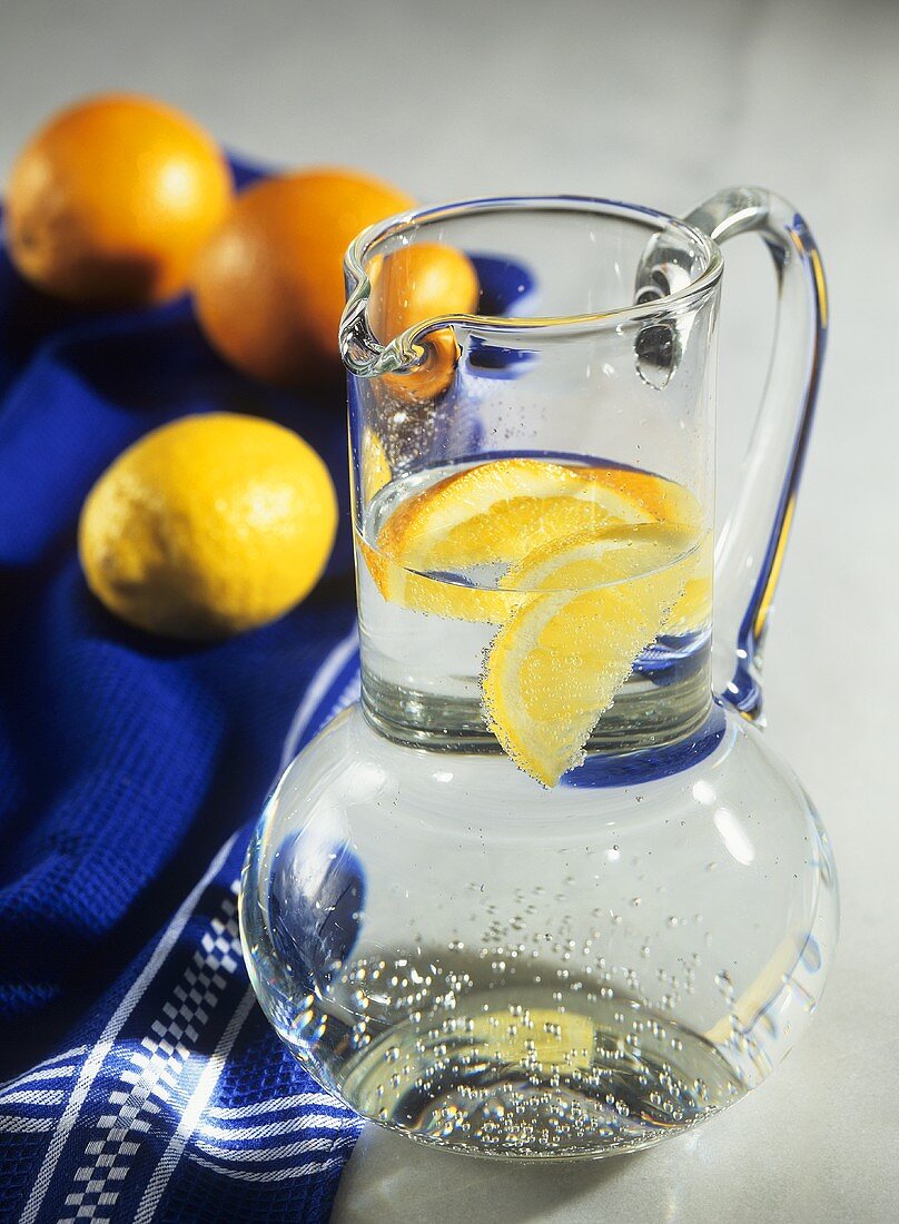 Mineralwasser mit Zitronen- und Orangenschnitzen im Glaskrug