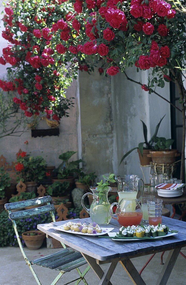Tisch mit Häppchen und Limonaden auf einer Terrasse