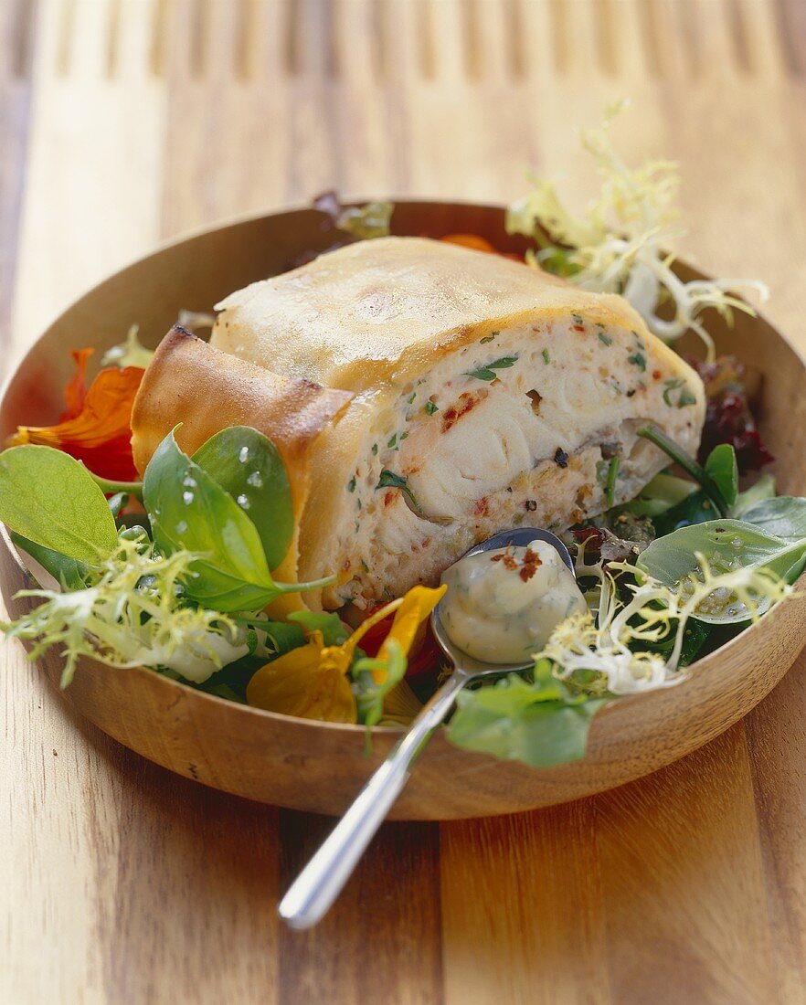 Salmon and zander strudel with honey, mustard and dill sauce on salad