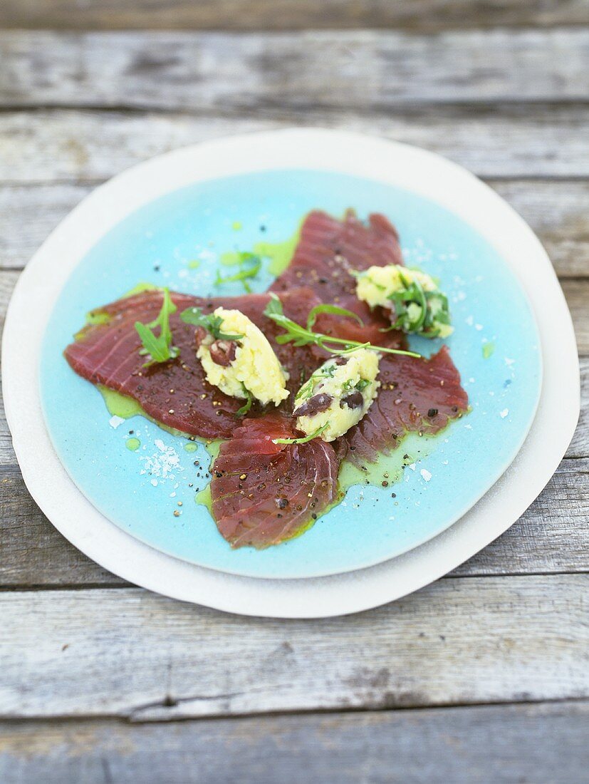 Marinated tuna with crushed potatoes, olives and rocket