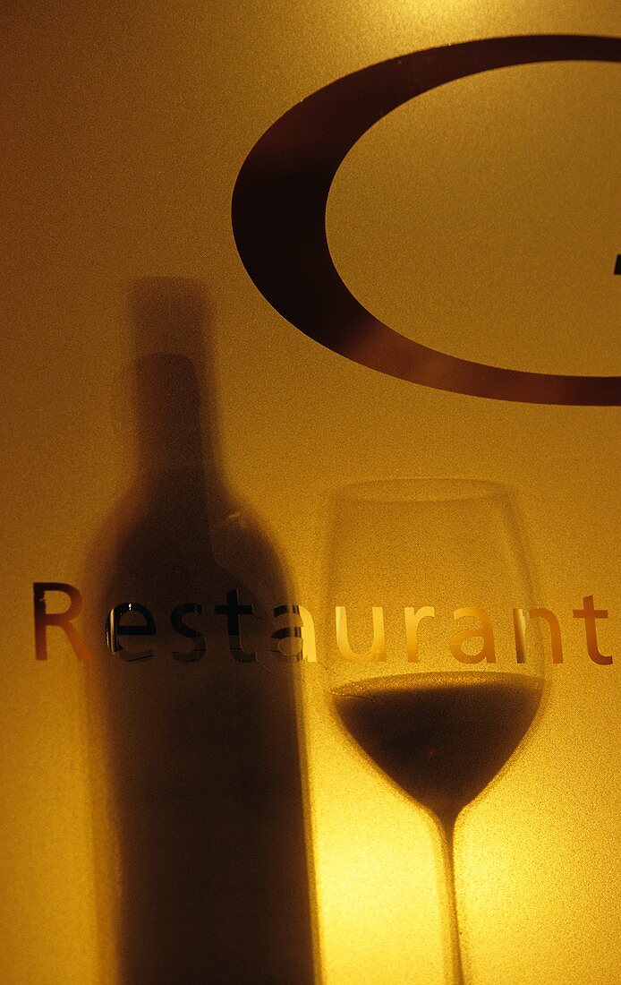 Schatten einer Weinflasche mit Glas auf Schriftzug Restaurant