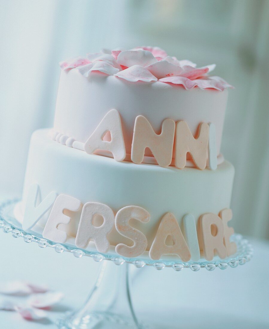 A white, two-tier birthday cake with writing