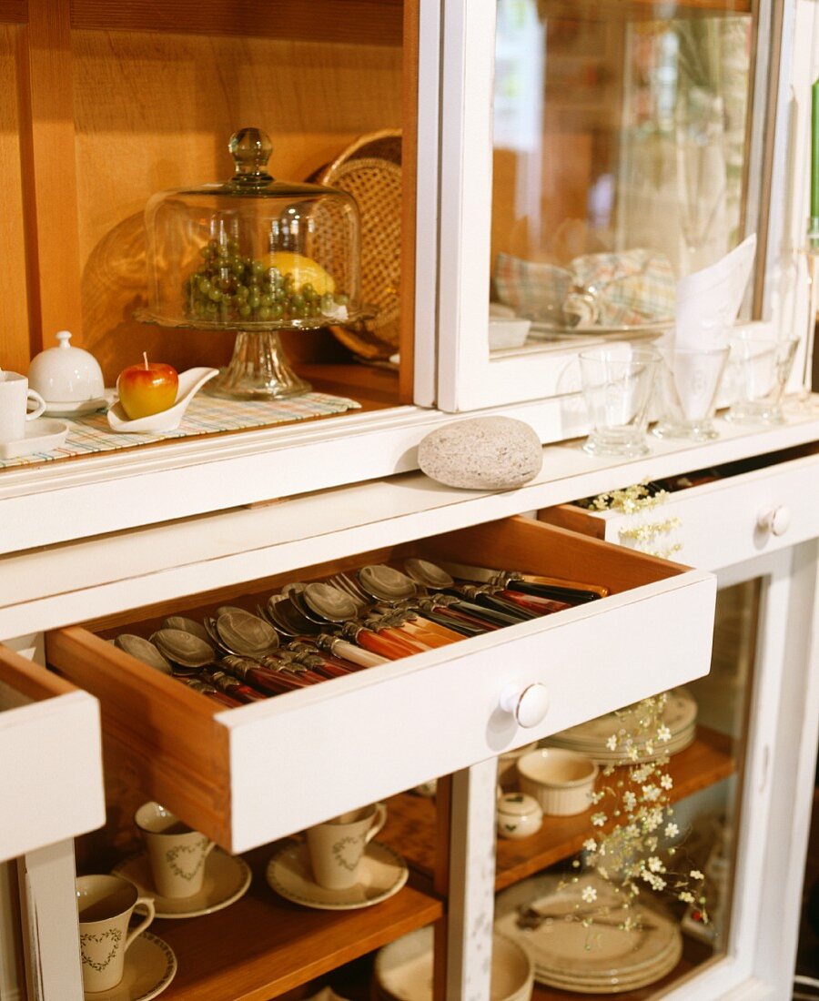 A crockery cupboard with cutlery drawers