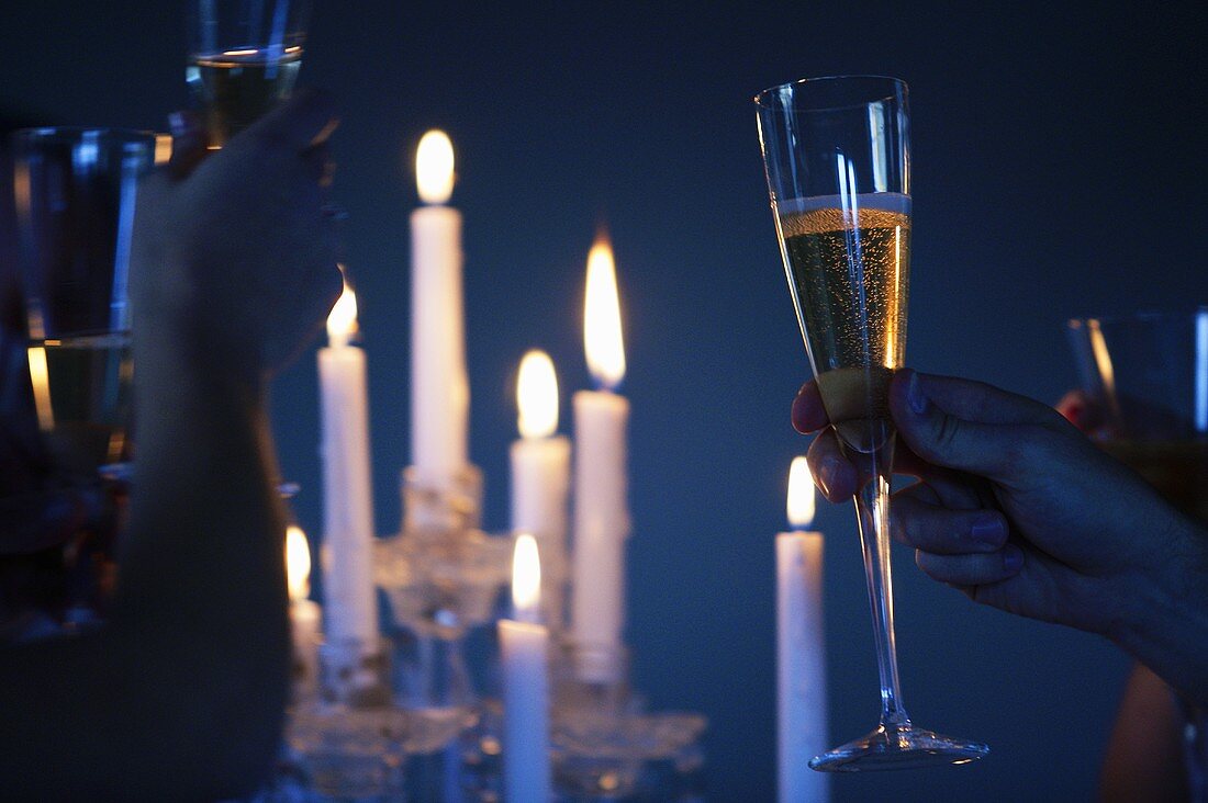 Toasting with champagne glasses by candlelight