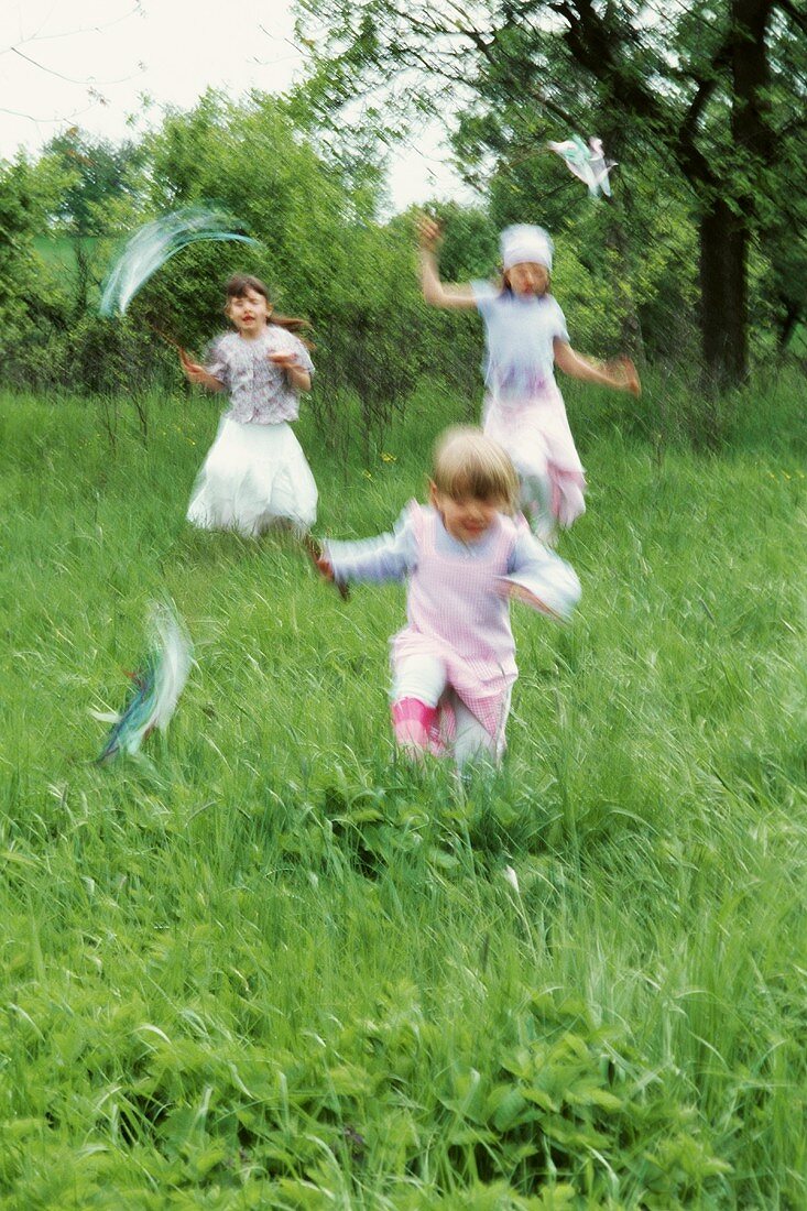 Three girls skipping through the grass