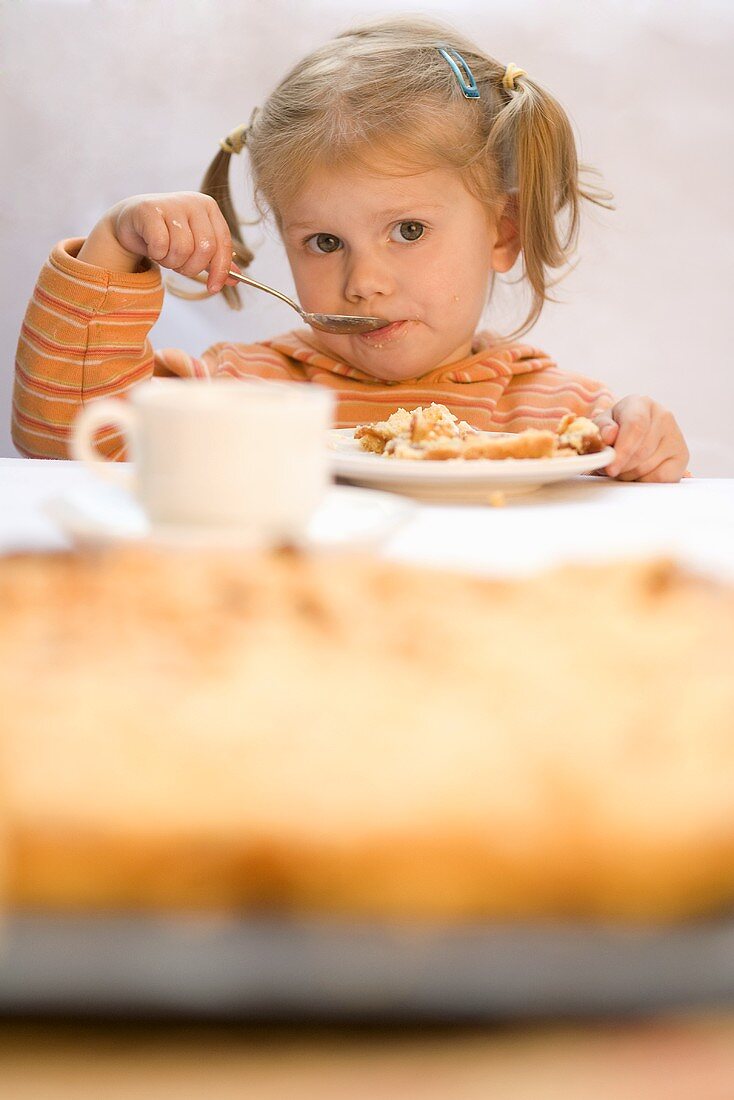 Kleines Mädchen isst Quittenkuchen