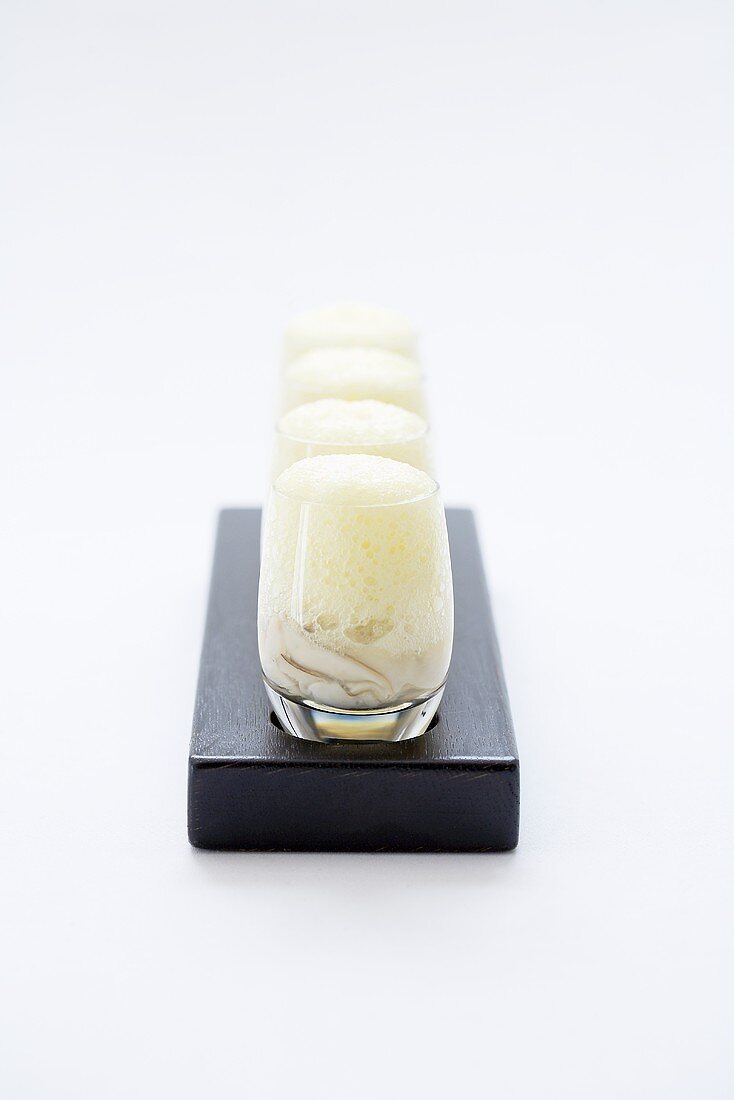 Oysters in a glass with foam
