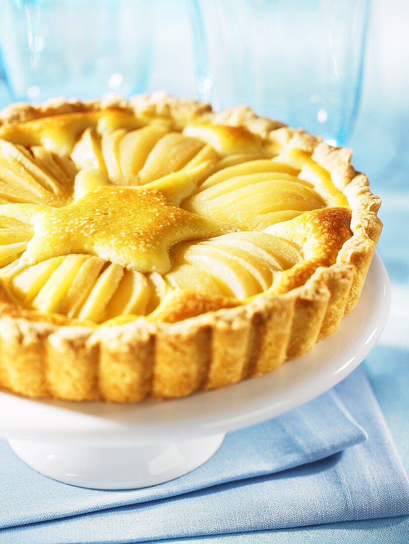 Pear and almond tart on a cake stand