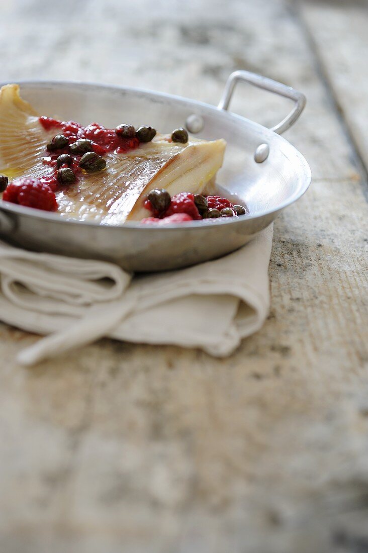 Fried ray fins with capers and raspberries