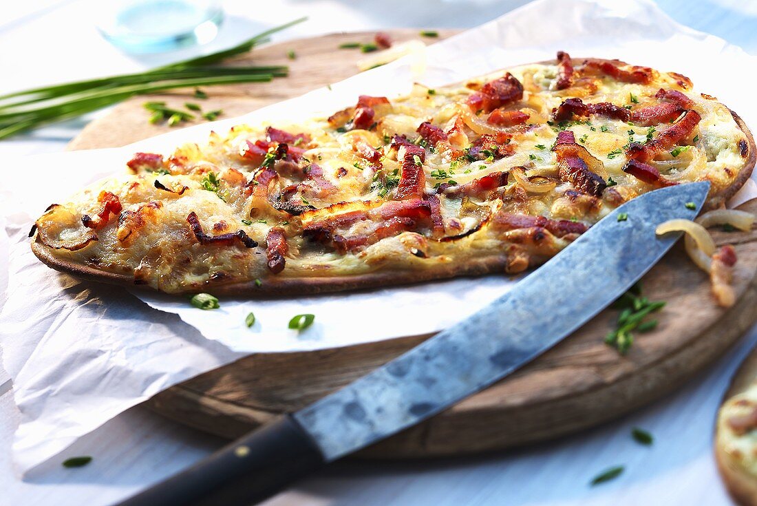 Tarte flambée with bacon, onions, spring onions and cheese