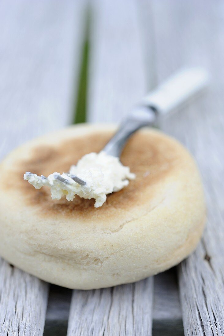 English Muffin und Gabel mit Resten von Frischkäse