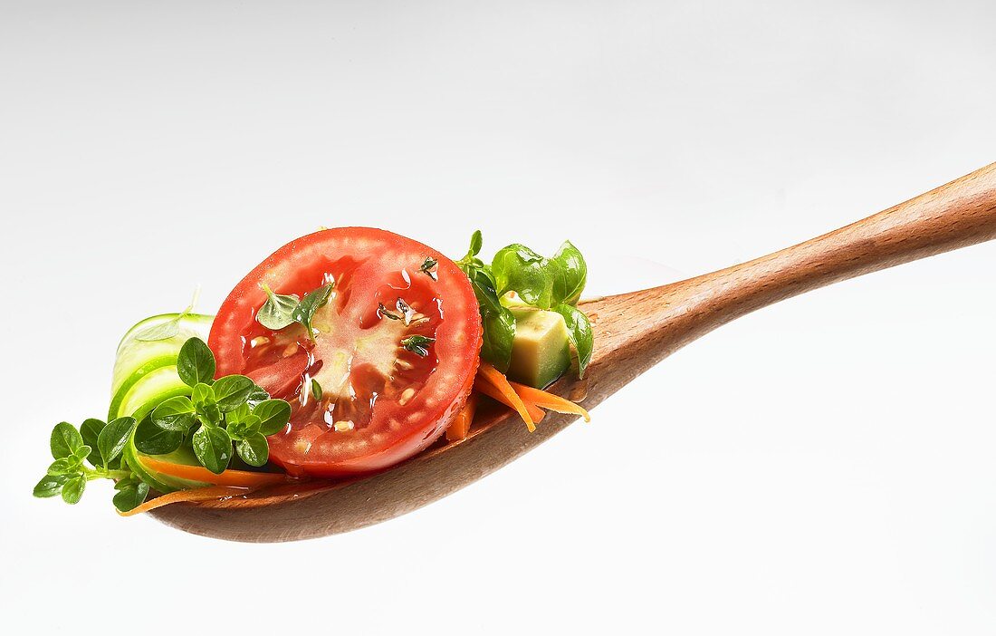 Tomatenscheibe, Avocado und Gurke mit Kräutern auf Holzlöffel
