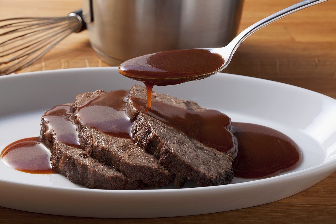 Roast beef being served with gravy