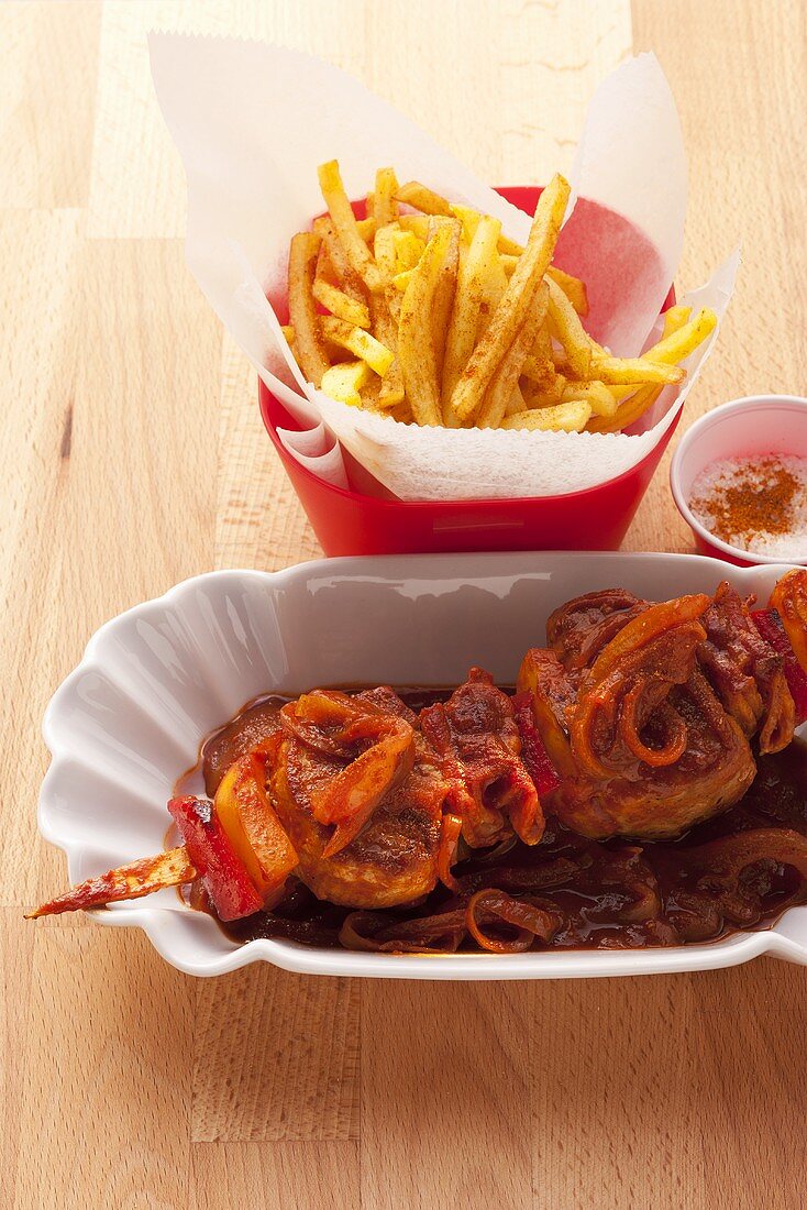 Schweinefiletspiess mit Schaschlicksauce und Pommes