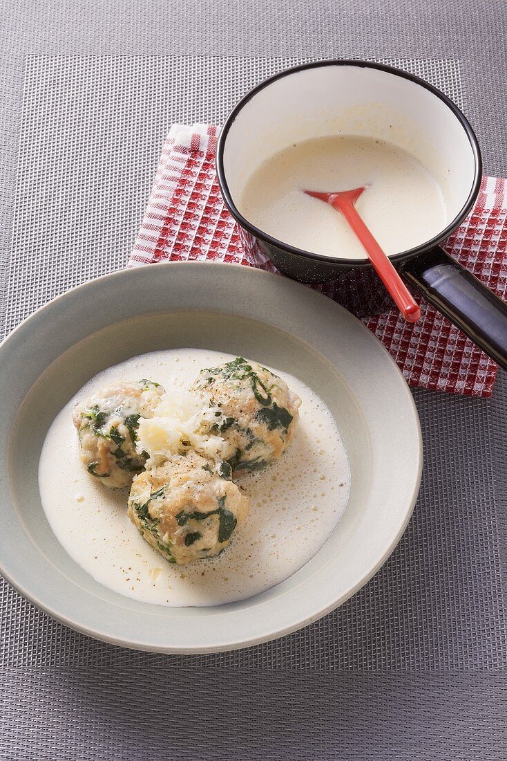 Spinach and bread dumplings in a white cheese sauce