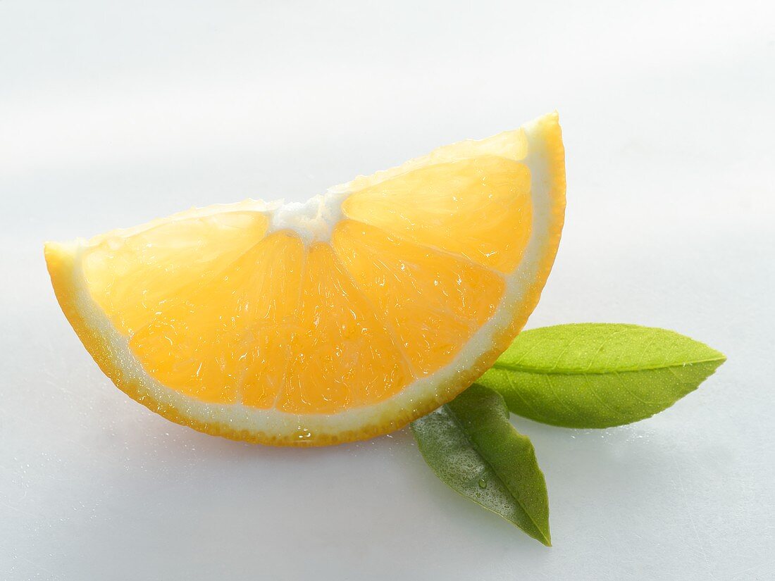 Ein Orangenschnitz und zwei Blätter