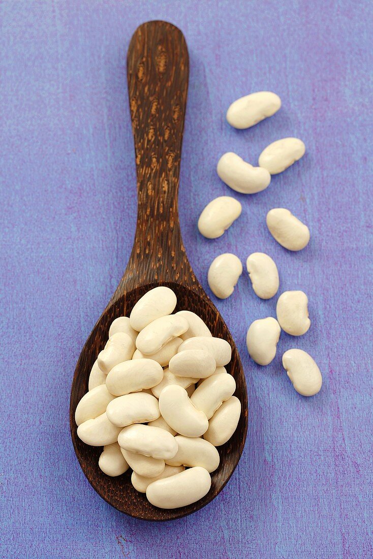 White beans on a wooden spoon