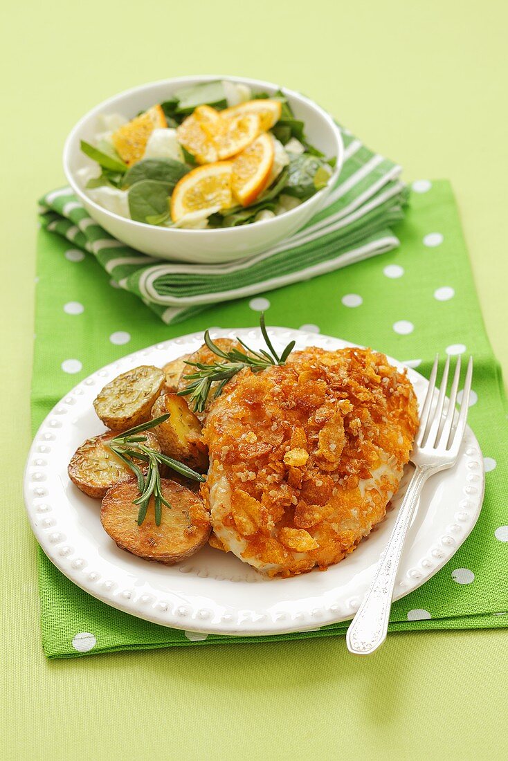 Chicken fillet covered with cornflakes with fried potatoes