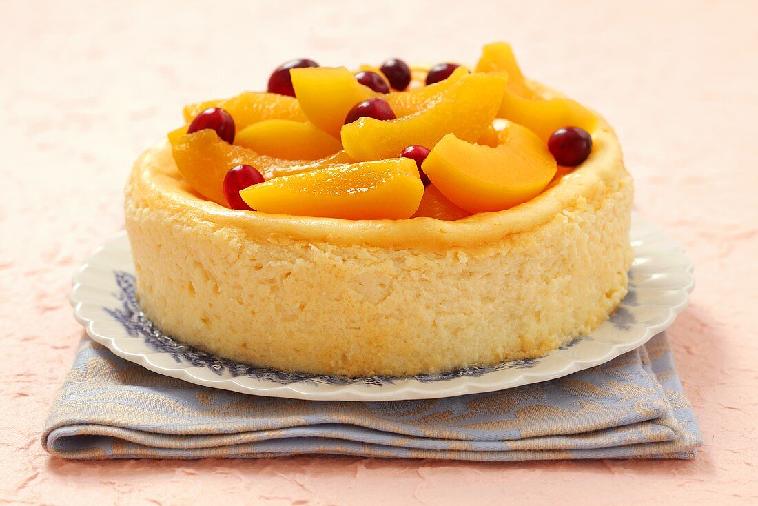 Cheesecake with peach slices and cranberries