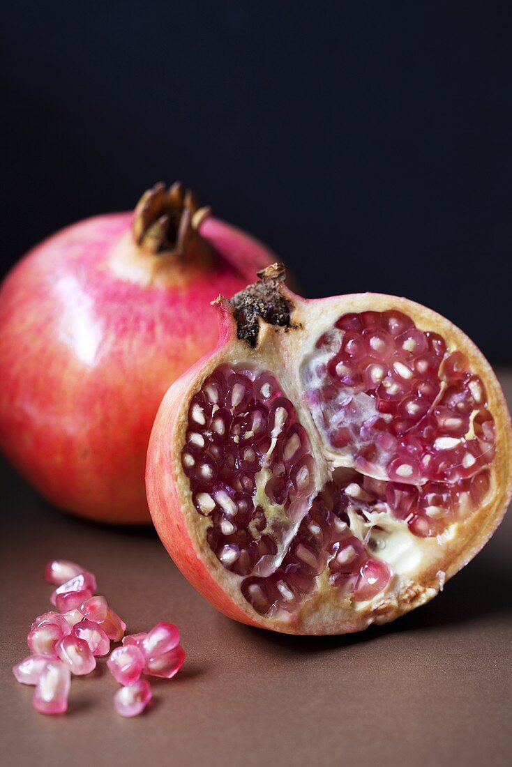 Pomegranates (whole and halved) and pomegranate seeds