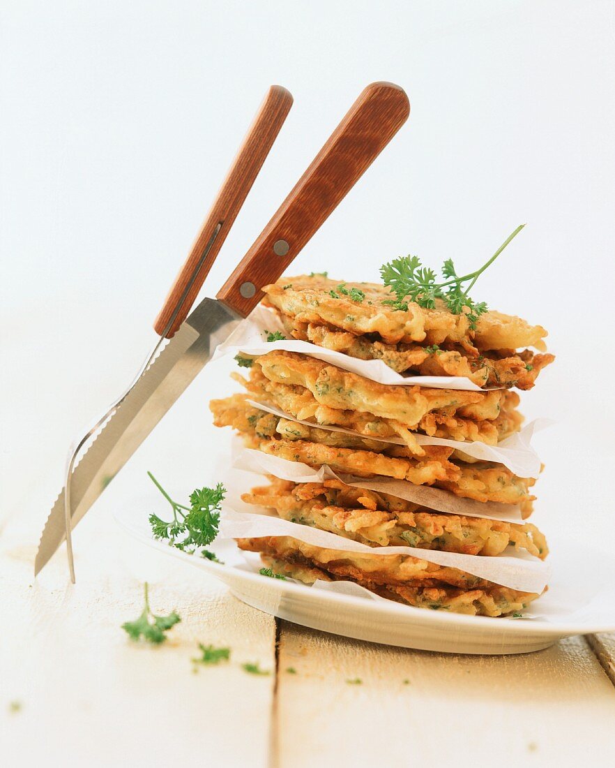 A stack of potato cake on a plate with herbs
