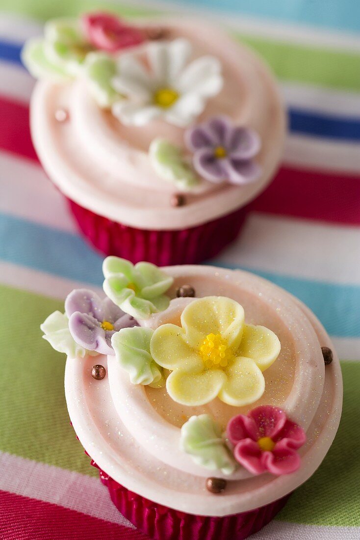 Two cupcakes with sugar flowers