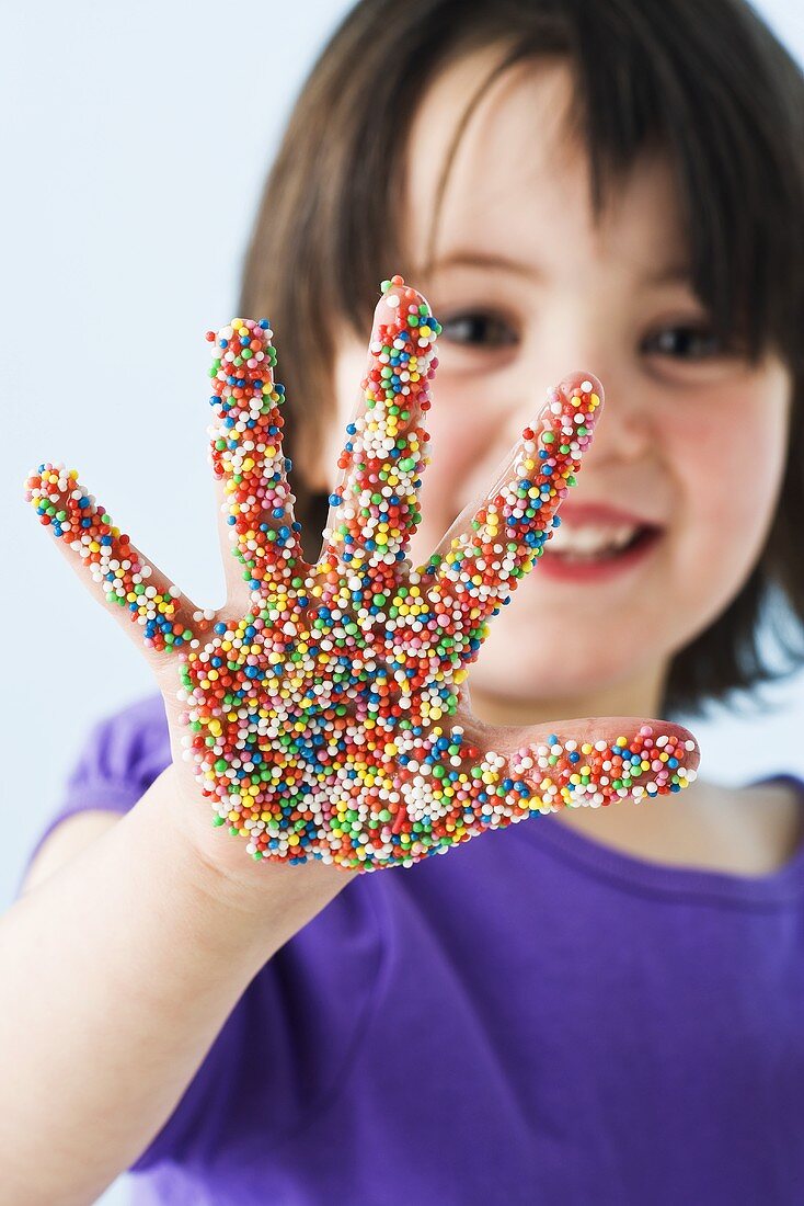 Girl with her hand covered in sprinkles