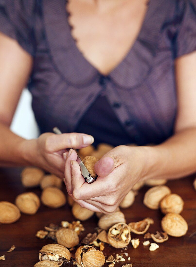 Woman cracking walnuts with nutcracker