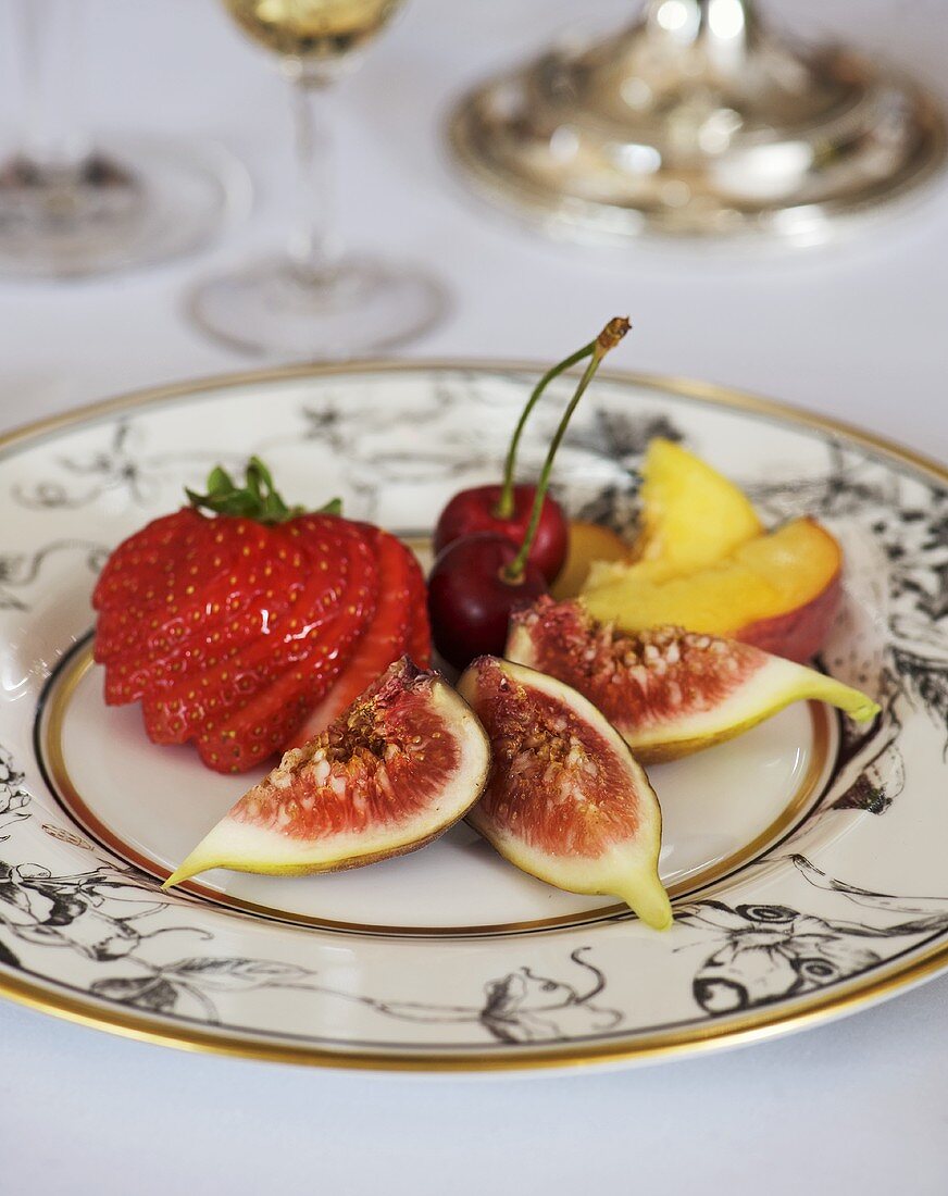 Plate of fruit: fig, strawberry, cherries and peach